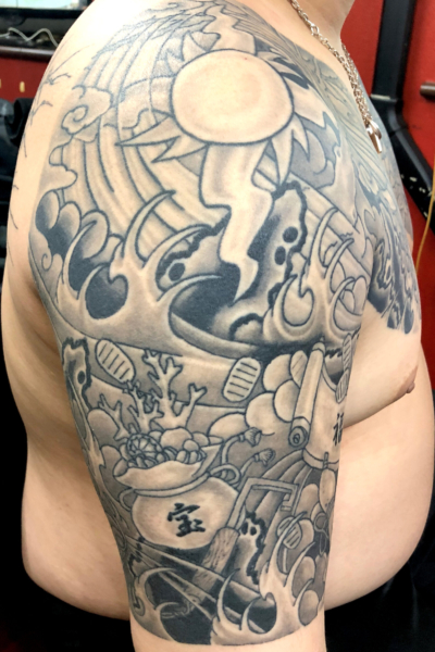 和彫り腕に「太陽と風波雲影と和小物」の刺青