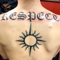 背中にワードタトゥーと太陽のトライバル