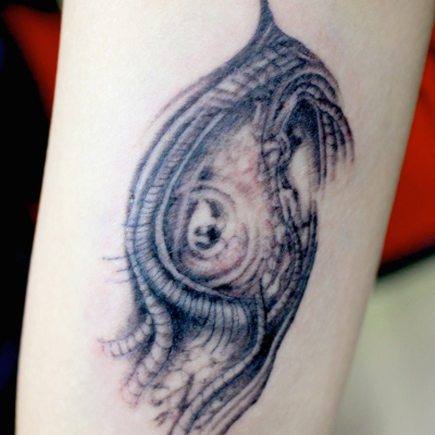 和彫り腕胸に「バイオメカノイド」の刺青