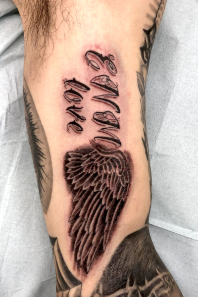 B&G 腕に「文字と翼」のタトゥー