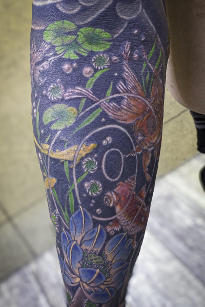 和彫り腕に「金魚とメダカと蓮と水草」の刺青