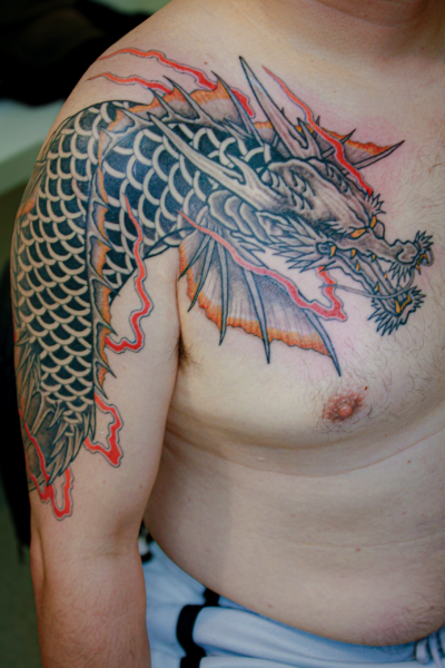 和彫り腕胸に「龍魚」の刺青
