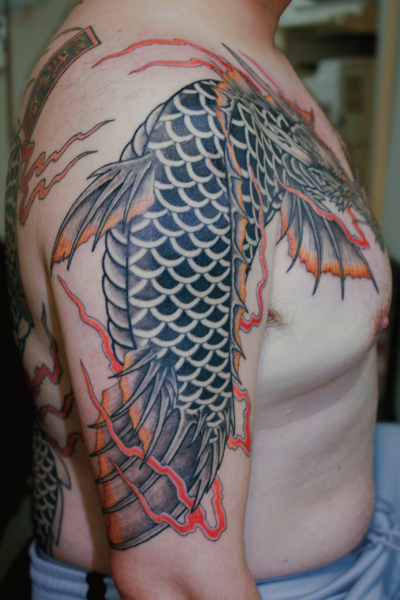 和彫り腕胸に「龍魚」の刺青