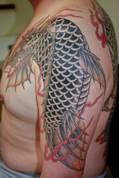 和彫り腕胸に「龍魚」の刺青