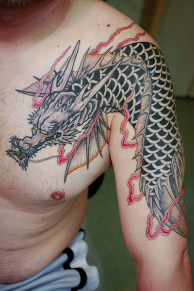 和彫り腕胸に「龍魚」の刺青
