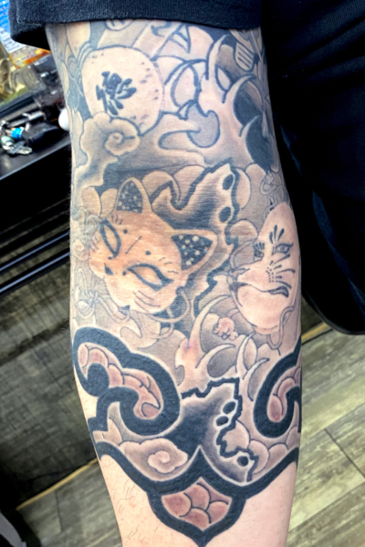 和彫り腕に「猫面と狐面」の刺青