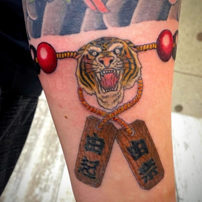 和彫り腕に「虎の頭と札が付いた数珠」の刺青