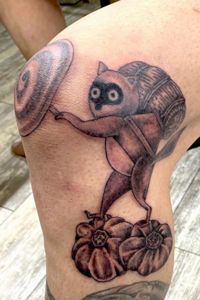 和彫り足に「傘を持って米俵を背負った狸が南瓜に乗っている」刺青