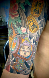 和彫り腕に「打ち出の小槌と小判と植物」の刺青