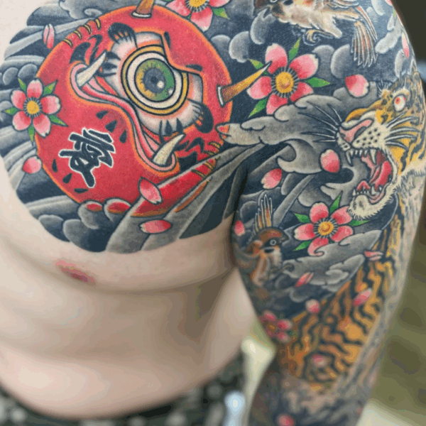 和彫り腕胸に「変わり達磨と動植物」の刺青