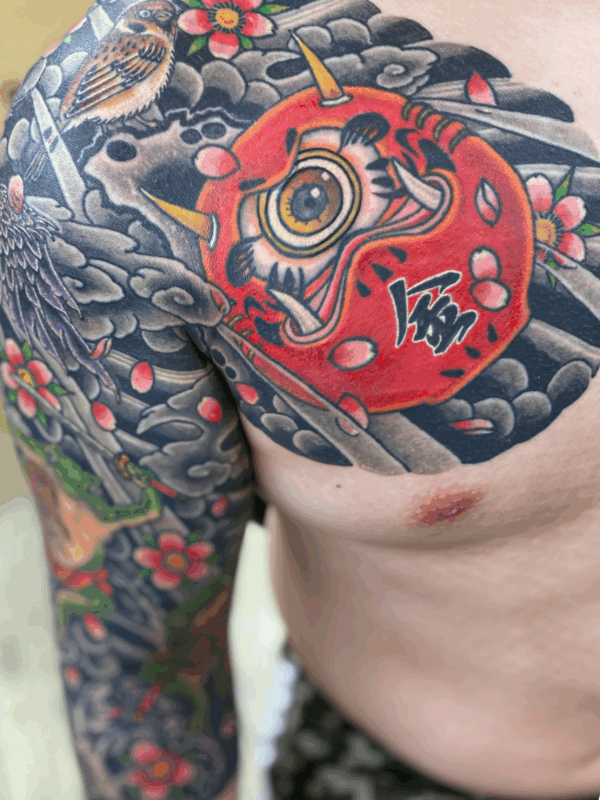 和彫り腕胸に「変わり達磨と動植物」の刺青