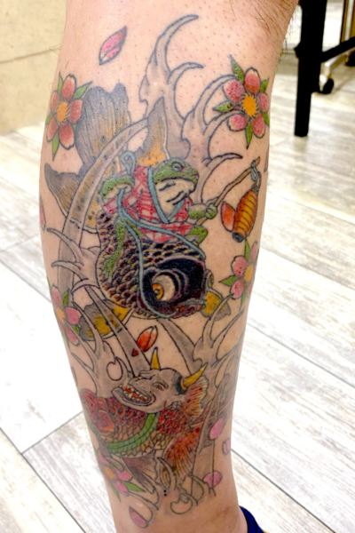 和彫り足に「金魚を操る蛙」の刺青