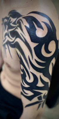 腕胸にトライバルタトゥー