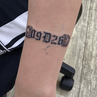 腕に「文字とサイコロ」のタトゥー