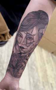 B&G 腕に「人物と百合」のブラックアンドグレータトゥー